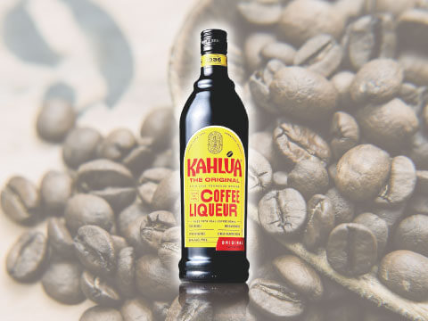 珈琲豆を背景としたコーヒーリキュール・カルーアのボトル