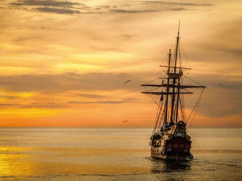 夕日の中進む帆船